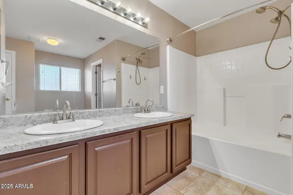 a bathroom with a granite countertop sink a mirror and a shower