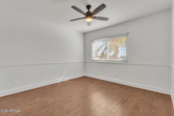an empty room with a window and a ceiling fan