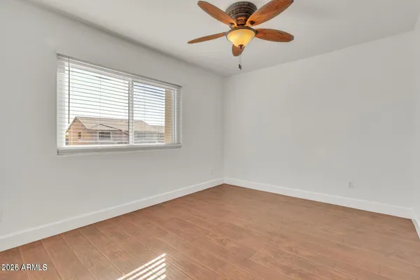 an empty room with a window and a fan