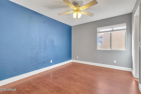 an empty room with windows and fan