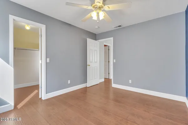an empty room with closet and a chandelier fan