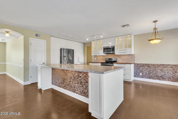 a kitchen with stainless steel appliances granite countertop a stove a sink and a refrigerator