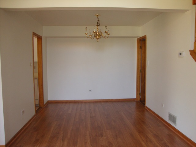 19201 Weber Road Mokena, IL 60448 - Photo 4 of 15 an empty room with wooden floor and ceiling fan