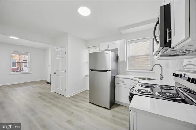 a kitchen with a stove a refrigerator and a sink