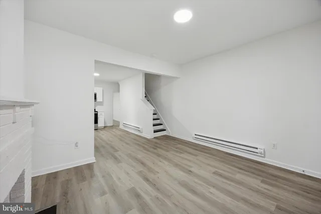 an empty room with wooden floor and white walls
