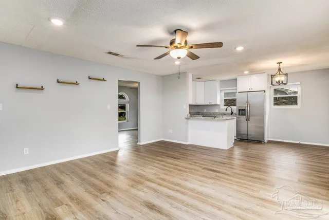 a view of a kitchen with wooden floor a sink and dishwasher
