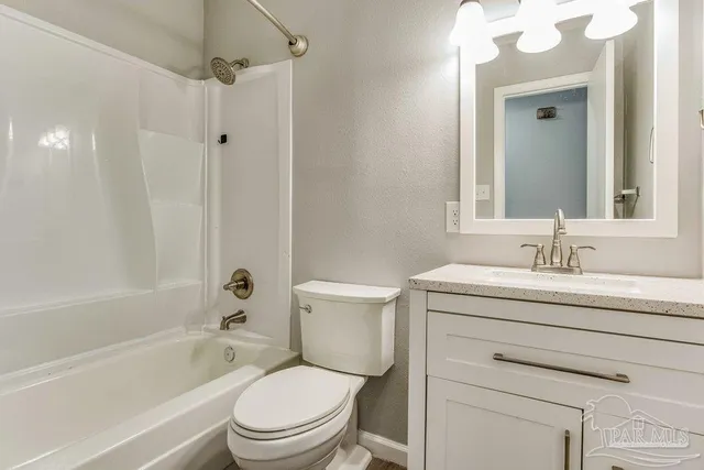 a bathroom with a granite countertop toilet a sink and a bathtub