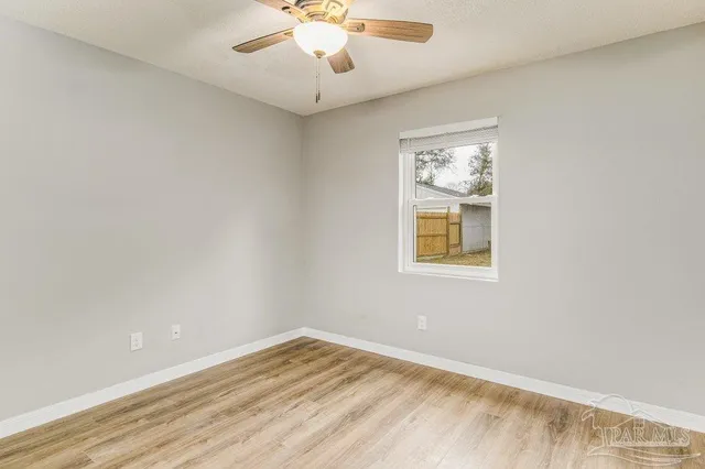 en empty room with wooden floor and windows