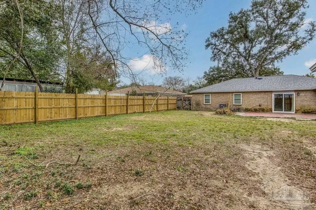 a view of backyard with wooden fence