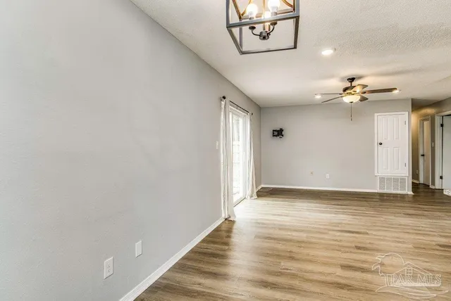 a view of an empty room with wooden floor