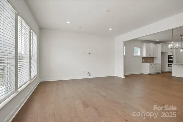 a view of empty room with a kitchen