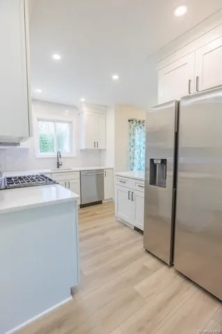 a large kitchen with cabinets and stainless steel appliances