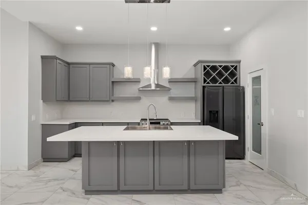 a kitchen with kitchen island cabinets a sink and a counter top space