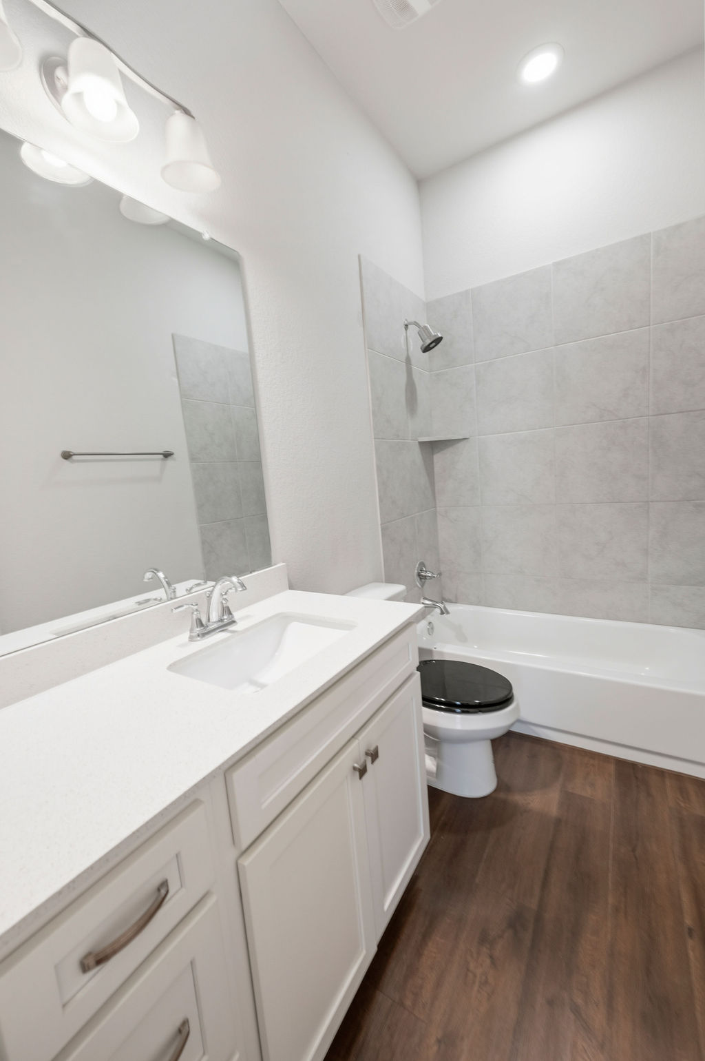 2032 Base Burner Path Leander, TX 78641 - Photo 23 of 34 Bathroom featuring a white vanity with a rectangular undermount sink, a large wall mirror, and wood-finish flooring