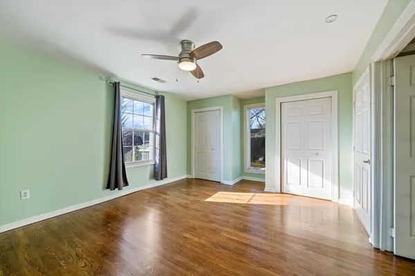a view of a livingroom with a chandelier fan and windows