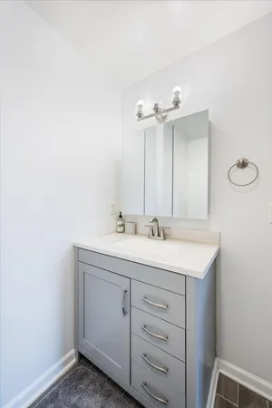 a bathroom with a granite countertop sink and a mirror