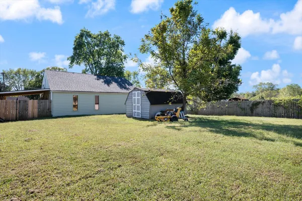 a view of a house with a yard and a tree
