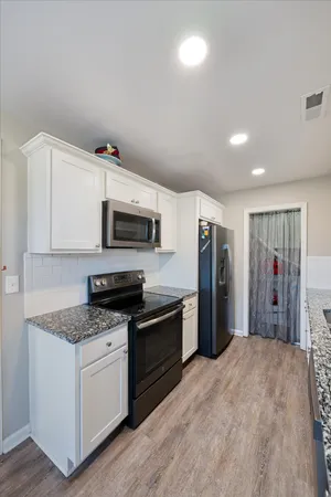 a kitchen with stainless steel appliances granite countertop a stove a refrigerator and a sink