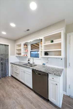 a kitchen with granite countertop stainless steel appliances a sink and cabinets