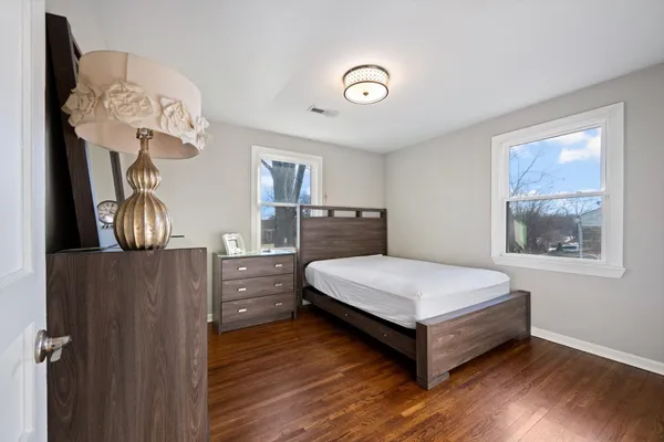 a bedroom with a bed and wooden floor