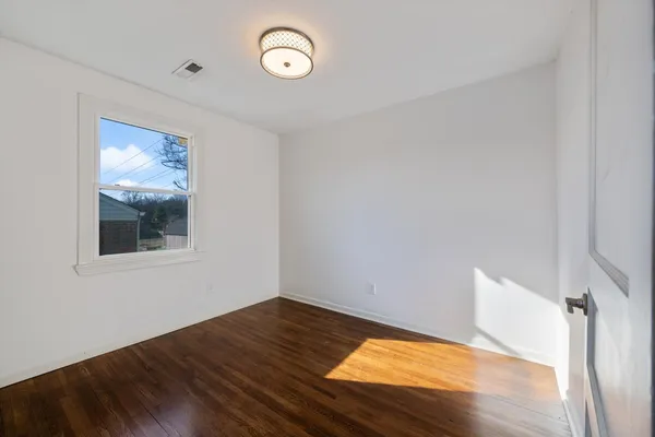 a view of a room with wooden floor and window