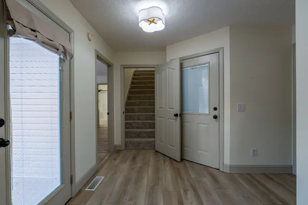 a view of a hallway with wooden floor and closet