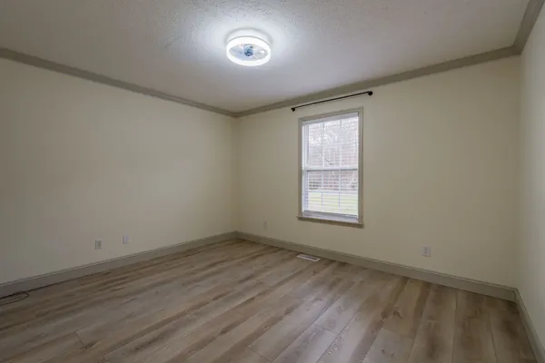 wooden floor in an empty room with a window