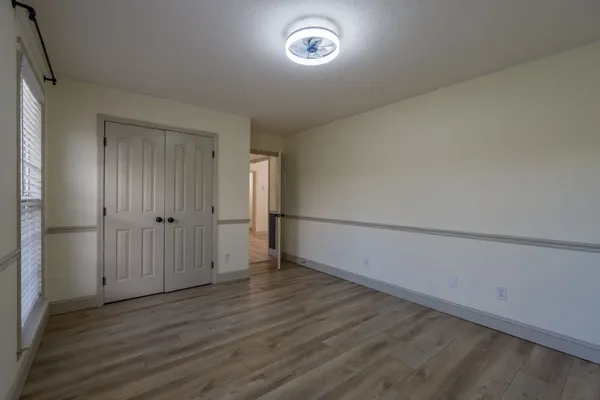 an empty room with wooden floor and windows