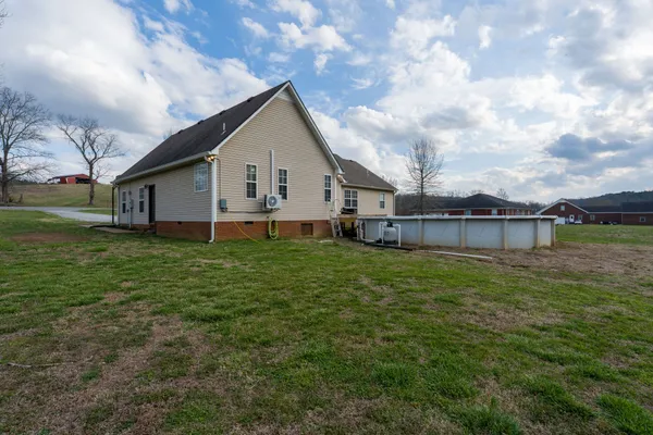 a view of a house with a big yard and large trees