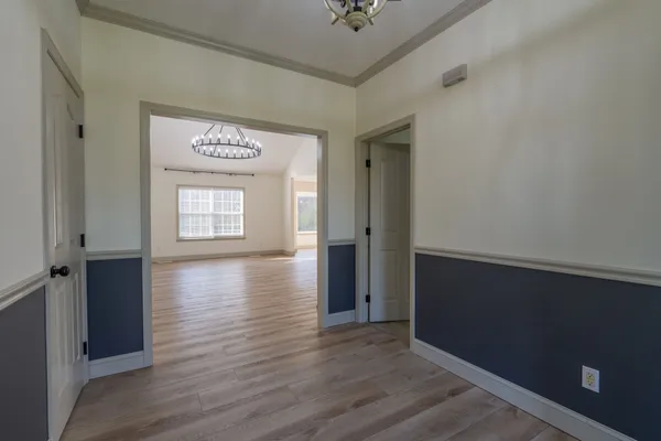 an empty room with wooden floor closet and windows