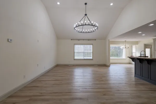 a view of big room with wooden floor and chandelier