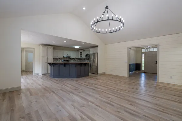 a view of a kitchen with wooden floor and a chandelier