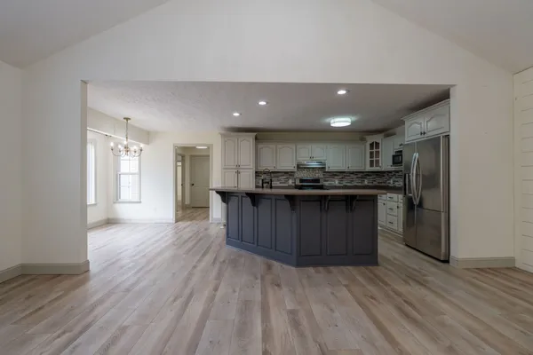 a kitchen with stainless steel appliances granite countertop a large counter top and wooden floors