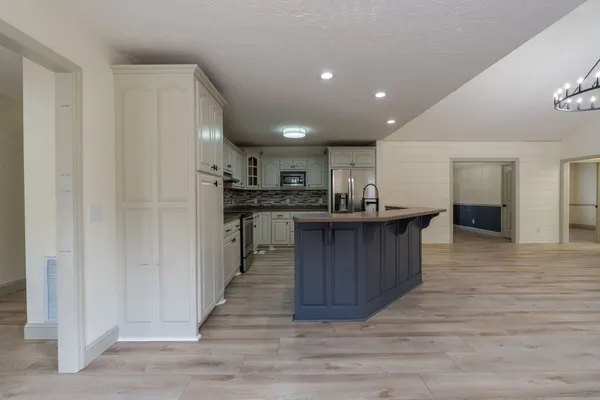 a kitchen with stainless steel appliances granite countertop a stove a sink a refrigerator and cabinets