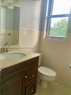 555 Northeast 30th Street, Unit 203 Miami, FL 33137 - Photo 14 of 23 a bathroom with a granite countertop sink a toilet and a window