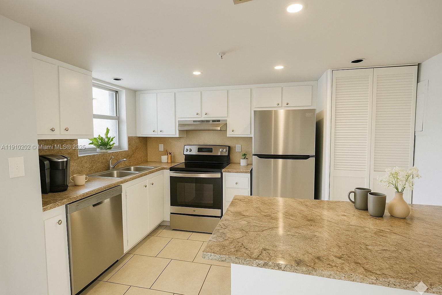 555 Northeast 30th Street, Unit 203 Miami, FL 33137 - Photo 3 of 23 a kitchen with granite countertop a refrigerator sink and microwave