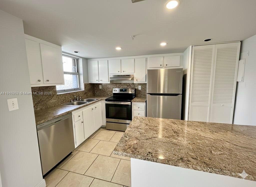 555 Northeast 30th Street, Unit 203 Miami, FL 33137 - Photo 6 of 23 a kitchen with granite countertop a refrigerator and a sink
