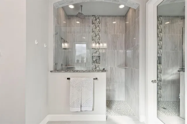 a bathroom with a granite countertop sink a shower and a mirror
