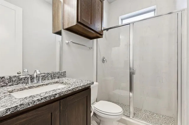 a bathroom with a granite countertop sink toilet and shower