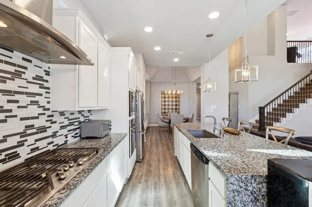 a kitchen with sink stove and cabinets
