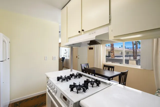 a kitchen with a sink stove and wooden floor