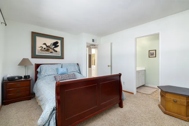 a bedroom with a bed and a painting on the wall