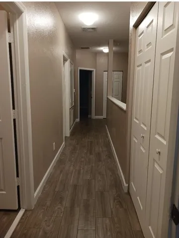 a view of a hallway with wooden floor