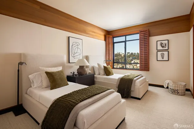 a bedroom with two beds and a large window