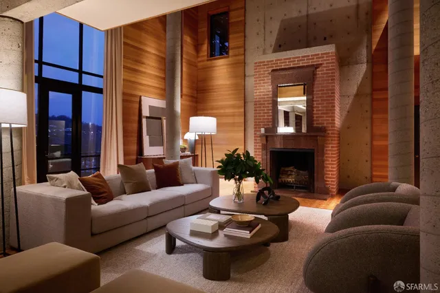 a living room with furniture a fireplace and a potted plant