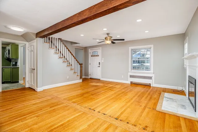a view of an empty room with window and a kitchen