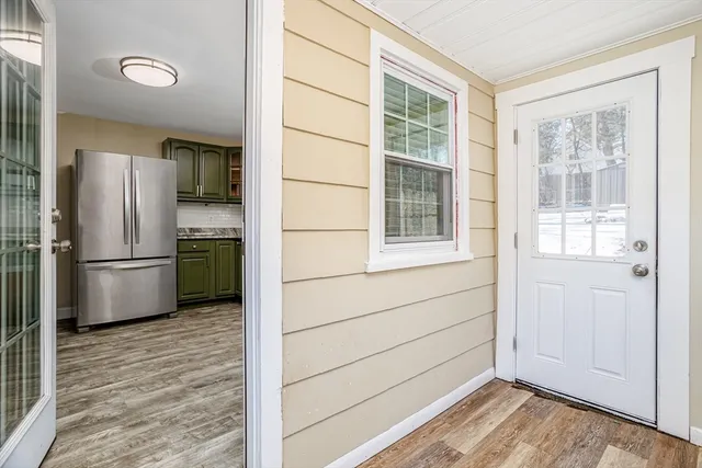 a kitchen with a refrigerator and wooden floor
