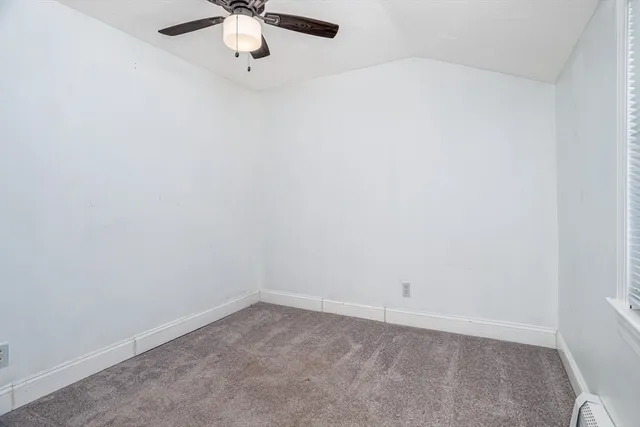 an empty room with a chandelier fan