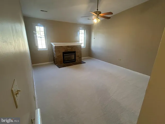 an empty room with fireplace and windows