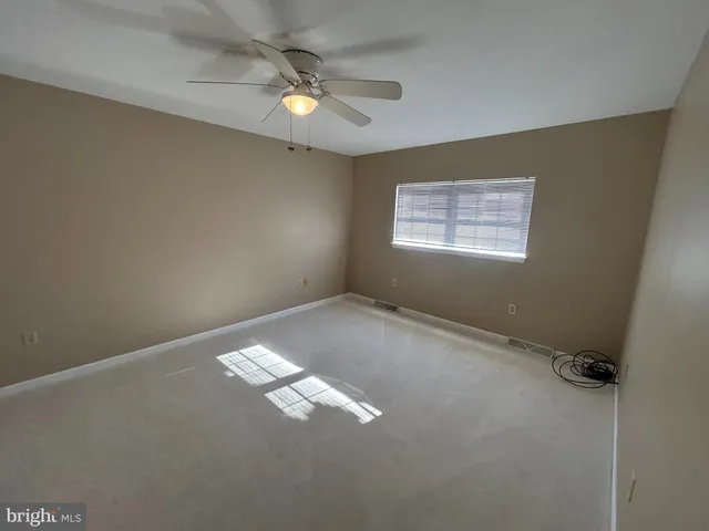 an empty room with closet and a ceiling fan